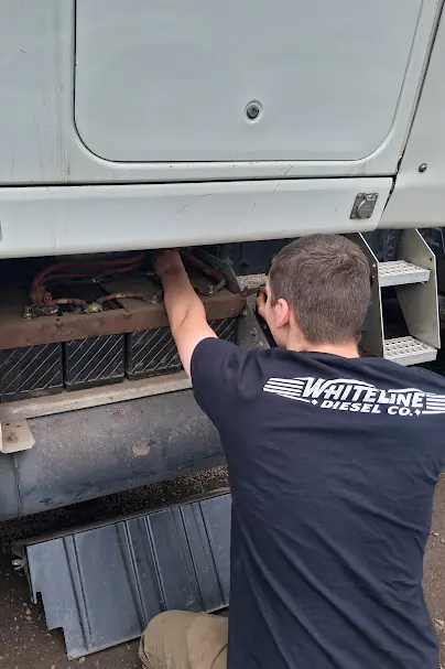 White Line Diesel mechanic servicing a commercial truck.